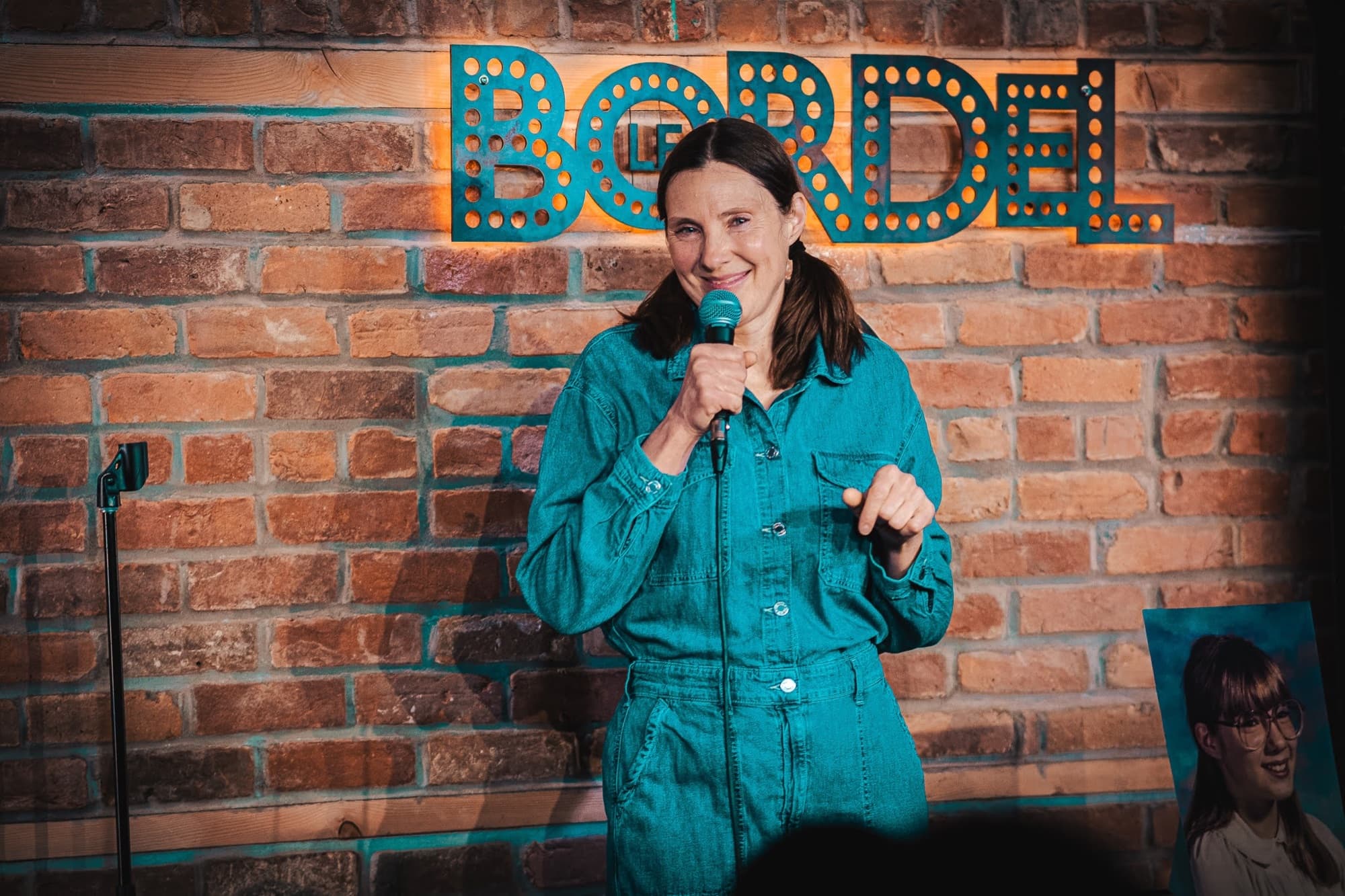 Marie-Pierre Poirier humoriste avec micro lors d'un spectacle.